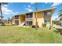 Exterior of a yellow two-story building with well-maintained lawn and mature palm trees at 101 Louella Ln # 11, Nokomis, FL 34275