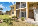 Well-manicured lawn leads to condo entrance with screened patio and staircase to upper units at 101 Louella Ln # 11, Nokomis, FL 34275