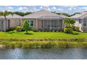 Beautiful backyard view with a screened lanai overlooking a pond and lush landscaping at 11026 Barnsley Dr, Venice, FL 34293