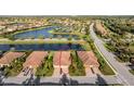 Aerial view of this property highlighting lake views in a desirable neighborhood with mature trees and landscaping at 115 Babbling Brook Run, Bradenton, FL 34212