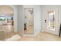 Bright foyer featuring tile floors, a decorative mirror, and a glass-paneled front door that brings in natural light at 115 Babbling Brook Run, Bradenton, FL 34212