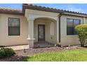 Covered front porch with brick walkway, decorative columns and arched entry at 115 Babbling Brook Run, Bradenton, FL 34212