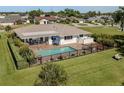 Aerial view of a backyard featuring a sparkling pool, patio with outdoor furniture, and a fenced-in yard at 1232 Pine Needle Rd, Venice, FL 34285