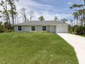 Charming single-story home boasts a well-manicured lawn and an attached one car garage at 15232 Faulkner Ave, Port Charlotte, FL 33953
