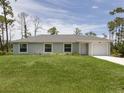 Charming single-story home boasts a well-manicured lawn and an attached one car garage at 15232 Faulkner Ave, Port Charlotte, FL 33953