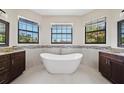 Luxurious bathroom featuring a standalone tub and stylish vanities with beautiful natural light at 172 Berthoud St, Port Charlotte, FL 33953