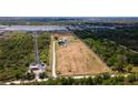 Expansive land parcel featuring a home, pond, and boat, outlined by a white property border at 1727 E Manasota Beach Rd, Englewood, FL 34223