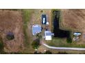 Birds-eye view of property, including a home, boat, pond, and vehicles, set on a large lot at 1727 E Manasota Beach Rd, Englewood, FL 34223