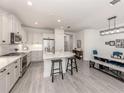 Modern kitchen featuring white cabinets, stainless steel appliances, a large island, and an open layout with the dining area at 18002 Franklin Park Ct, Venice, FL 34293
