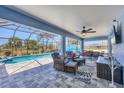 An outdoor screened in patio with comfortable seating, a ceiling fan, and views of the pool at 194 Sportsman Rd, Rotonda West, FL 33947