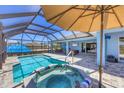 The screened-in pool area features a heated pool, spa, and a covered patio area for lounging at 194 Sportsman Rd, Rotonda West, FL 33947