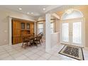 Cozy dining area with built-in cabinet, round table, arched windows, and decorative entry doors at 201 Bayside Ct, Nokomis, FL 34275