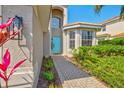 Inviting front entrance with a bright blue door, brick pathway, and manicured landscaping at 2197 Mesic Hammock Way, Venice, FL 34292