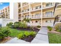 Manicured landscaping surrounding condo units, including flowering shrubs and palm trees by sidewalk at 230 Santa Maria St # 333, Venice, FL 34285