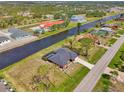 An elevated view capturing a single-story residence near a waterfront with verdant lawns and a peaceful neighborhood ambience at 233 Rotonda Cir, Rotonda West, FL 33947