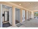 Condo entryway with sightlines to a kitchen with stainless steel appliances and a hallway with storage at 2405 N Beach Rd # 4, Englewood, FL 34223