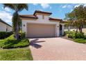 A lovely home with a terracotta roof, two-car garage and brick paved driveway at 24153 Spartina Dr, Venice, FL 34293