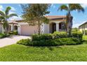 Charming home with a well-manicured lawn, paver driveway, and lush landscaping at 24153 Spartina Dr, Venice, FL 34293