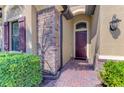 Close up of a beautiful front entrance to a home with brick walkway and well maintained landscaping at 24193 Gallberry Dr, Venice, FL 34293