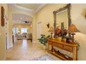 Inviting entryway with stylish console table, decorative mirror, and views of the living room at 2542 Cortenova Ct, Venice, FL 34292