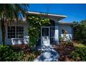 Close-up of home's entryway, showcasing the screened porch and landscaped walkway at 271 Manor Rd, Venice, FL 34293