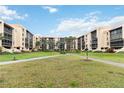Beautifully landscaped condominium courtyard with mature trees, walking paths, and well-maintained lawn at 3006 Caring Way # 304, Port Charlotte, FL 33952
