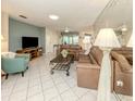 Inviting living room featuring tile floors, plush leather couches, and a decorative mirror wall for an open feel at 3167 Night Heron Ln, Venice, FL 34293