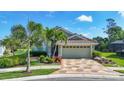 Charming home featuring beautiful landscaping, well-maintained lawn, and a decorative paver driveway at 3337 Pine Shadow Cir, North Port, FL 34287