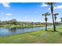 Scenic water view of condo complex overlooking lake with lillypads and lush greenery and palm trees at 414 Laurel Lake Dr # 203, Venice, FL 34292