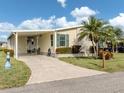 Beautiful home with a covered carport, manicured lawn, and well-maintained landscaping at 423 Pirates Pt, North Port, FL 34287