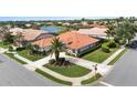 Aerial shot of home with mature landscaping, lovely tile roof, and backyard, in a quiet community with lake views at 4641 Gaeta Dr, Venice, FL 34293