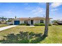 Inviting home exterior with a blue garage door, front yard landscaping, and a well-manicured lawn at 511 Porpoise Rd, Venice, FL 34293