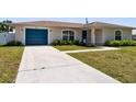 Charming home featuring a blue garage door, landscaped front yard, and well-maintained lawn at 511 Porpoise Rd, Venice, FL 34293