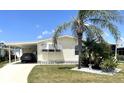 Exterior of a house with well maintained landscaping, driveway, and car in the car port at 537 Amberjack Dr, North Port, FL 34287