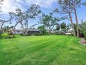 Expansive backyard with lush lawn and mature trees, perfect for outdoor activities at 608 Apalachicola Rd, Venice, FL 34285