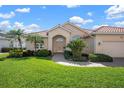 Charming single-story home featuring a red tile roof, paver driveway, and lush green landscaping at 744 Fringed Orchid Trl, Venice, FL 34293