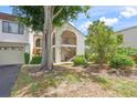 Attractive building exterior showcasing open stairways, lush landscaping, and large shade tree at 810 Capri Isles Blvd # 230, Venice, FL 34292