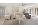 Bright living room featuring neutral walls, cozy carpeting, and a ceiling fan for optimal comfort at 810 Capri Isles Blvd # 230, Venice, FL 34292