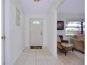 Bright entryway with tile flooring, a white front door, and a view into the adjacent living area at 990 Sea Fox Rd, Venice, FL 34293