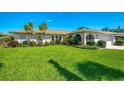 Charming home featuring a lush green lawn, mature landscaping, and a well-maintained exterior at 1004 Deer Run, Venice, FL 34293