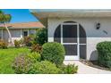 Inviting screened front entry with beautiful landscaping, offering a private and welcoming entrance to the home at 1004 Deer Run, Venice, FL 34293