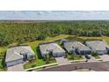 Aerial view of homes with tile roofs and a pond surrounded by lush greenery, offering a serene and picturesque setting at 10136 Coral Shore Dr, Englewood, FL 34223