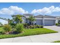 Charming single-story home with a gray tile roof, lush landscaping, and a spacious driveway at 10136 Coral Shore Dr, Englewood, FL 34223