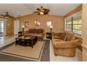 Cozy living room features plush seating, a ceiling fan, neutral tones and natural light at 1101 Southland Rd, Venice, FL 34293