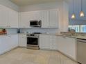 Bright kitchen with stainless steel appliances, white cabinets, and beautiful countertops at 13150 Huerta St, Venice, FL 34293