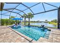 Relaxing screened-in pool area featuring a lake view and comfortable lounge chairs at 13511 Esposito St, Venice, FL 34293