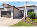 Charming home featuring a well-manicured lawn, paver walkway, and two-car garage at 13872 Rinuccio St, Venice, FL 34293