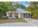 Charming single-story home featuring mature landscaping, a covered carport, and freshly painted exterior at 1629 Siesta Dr, Sarasota, FL 34239