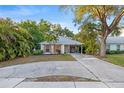 Inviting one-story home with a lush tropical landscape and a convenient covered carport space at 1629 Siesta Dr, Sarasota, FL 34239