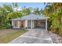 Cozy one-story home with a covered carport, complemented by tropical landscaping for added curb appeal at 1629 Siesta Dr, Sarasota, FL 34239